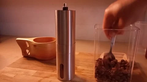 Man's hand put coffee beans into a coffee grinder Stock Footage 340357408