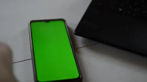Man's hand put iphone with green screen on a white table 스톡 동영상 200821601