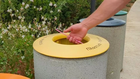Mans hand put plastic cocktail tube to the trash can. Waste sorting. Stock Footage 310168983