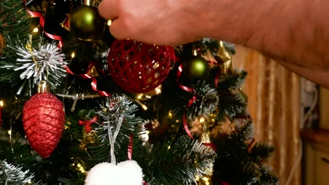 Mans hand put red ball on christmas tree Stock Footage 165240799