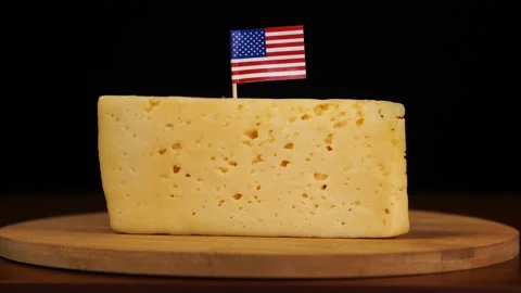 Man's hand put small in size toothpick with american flag on cheese. Stock Footage 159822068
