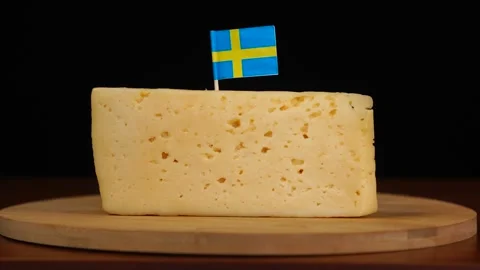 Man's hand put small in size toothpick with swedish flag on cheese. Stock Footage 159822205