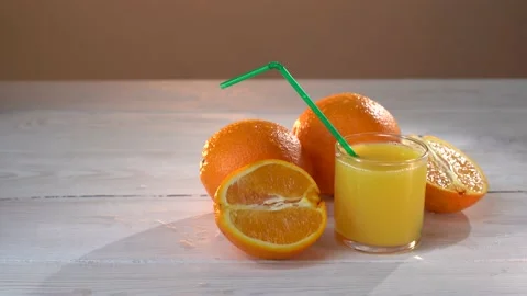 Man's hand put the straw into the glass of orange juice. Fantastic shot. 4k Stock Footage 154412958