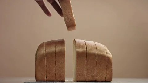 Man's hand put's back a slice of bread from brick bread 스톡 동영상 84595986