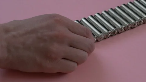 A man's hand puts a battery of aa size in a row to other same batteries 스톡 동영상 88717565
