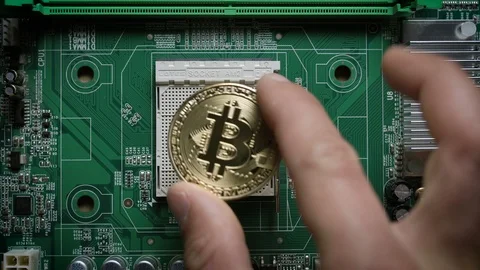 The man's hand puts the bitcoins in a column on the motherboard. Crypto currency Video stock 90452875