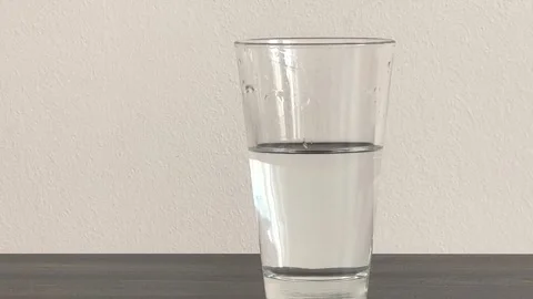 A man's hand puts down a glass of water after drinking it. brought a glass of Stock Footage 306329326