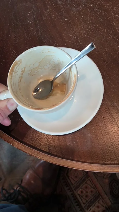 A man's hand puts a empty cup with a spoon on top of the saucer. Stock Footage 336976646