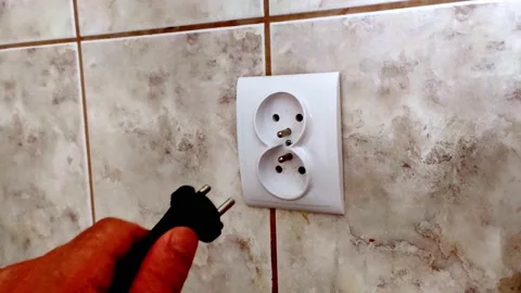 Man's hand puts it the wall plug socket. Hand plug into electricity socket Stock Footage 156635816