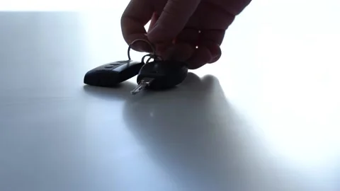 A man's hand puts the keys to the car on a white table Stock Footage 167551232