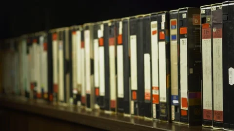 A man's hand puts one videotape on the shelf Stock Footage 162854616