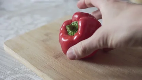 Man's hand puts pepper on the cutting board Stock Footage 131985046