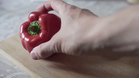 Man's hand puts pepper on the cutting board Stock Footage 131985262