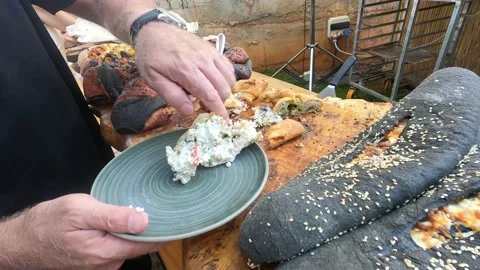 Man's hand puts piece fresh delicious stuffed pastry on plate in restaurant. Stock Footage 199035118
