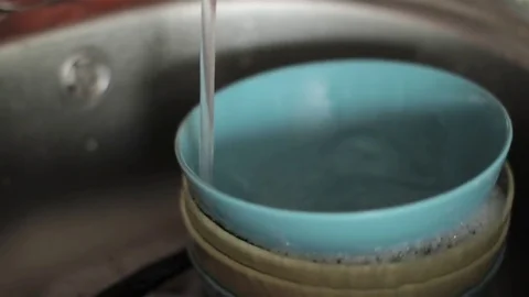 Man's Hand Puts the Plate in the Sink With the Water Included Stock-Footage 73685667