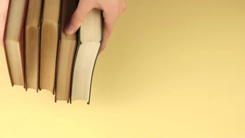 A man's hand puts a stack of books on the background Stock Footage 120299057