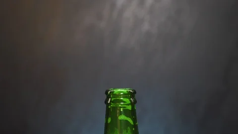 A man's hand puts a straw in a beer bottle. Stock Footage 102918645