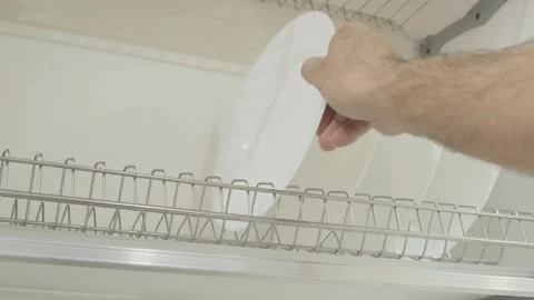 Man's hand puts washed clean white plate on dryer in  closet 스톡 동영상 271069409