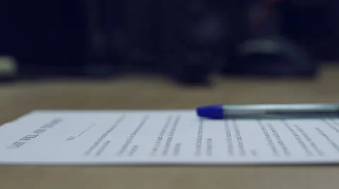 Man's hand putting assigned contract and pencil down to a desk. Video stock 43088207