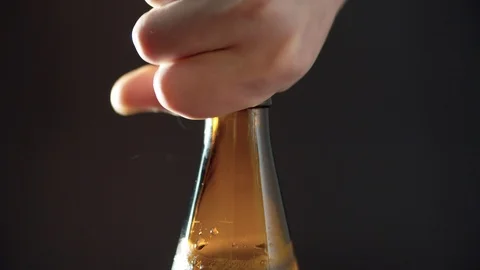 Man's hand putting bottle of beer on the table and opening it Stock Footage 124292784