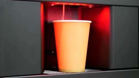 A man's hand putting a cardboard cup and making coffee with a coffee machine Stock Footage 228576383