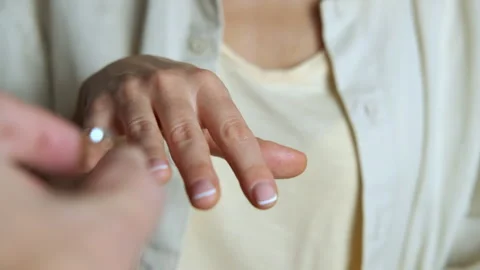 Man's hand putting engagement ring on woman's finger Stock-Footage 331774552
