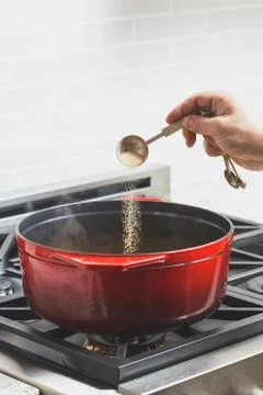 Man's hand putting spices while cooking food Stock Photos