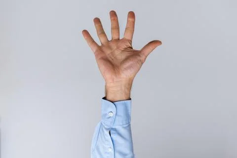 Man's hand raised, palm open with fingers spread to show five  versatile ge.. Stock Photos