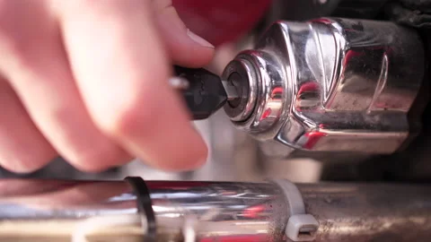 Man's hand rapidly inserting key into motorbike ignition keyhole and puts it out Stock Footage 151787226