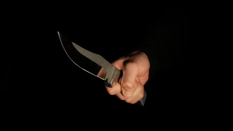 A man's hand reassuringly shows a large knife out of the dark Stock Footage 104804007