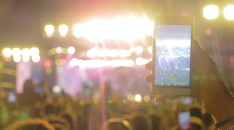 Man's hand is recording the rock concert in the crowd with his smartphone Stock Footage