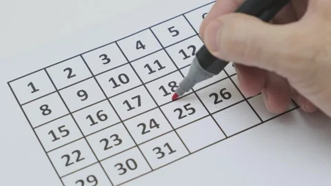Man's hand with red felt-tip pen marks the 18th day of month 動画素材 265880208