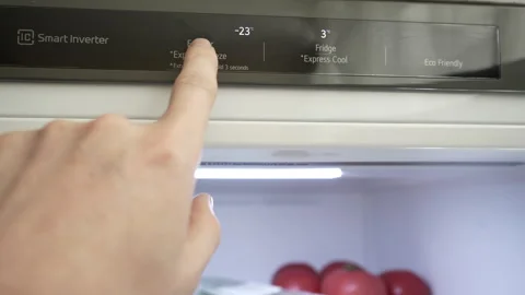 A man's hand regulates the temperature of the refrigerator and freezer Stock Footage 278728419