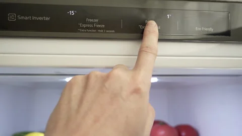 A man's hand regulates the temperature of the refrigerator and freezer Stock Footage 279153432