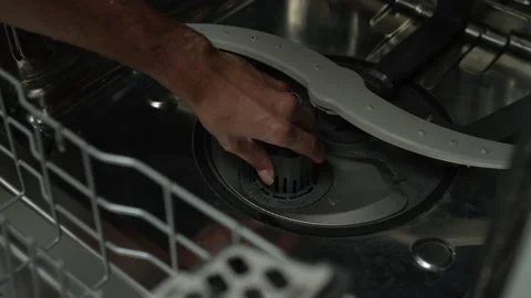 Man's hand removes the filter from the bottom of the dishwasher in the kitchen Stock Footage 147612955