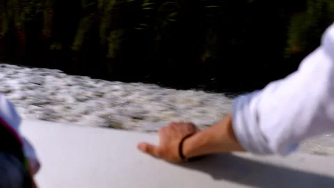 A man's hand rests on the side of a speedboat yacht. The boat is sailing fast on Stock Footage 253877033