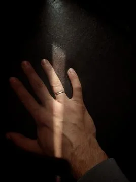 Man's hand with a ring on the ring finger of a leather sofa Foto stock
