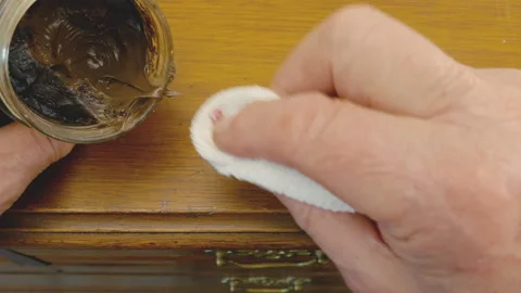 Man’s hand rubbing beeswax into an old piece of furniture. Vídeos de archivo 243745785