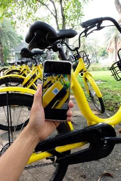 Man's hand scanning a QR code using smart phone to unlock bike,Modern smart p Stock Photos