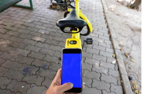 Man's hand scanning a QR code using smart phone to unlock bike,Modern smart p Stock Photos