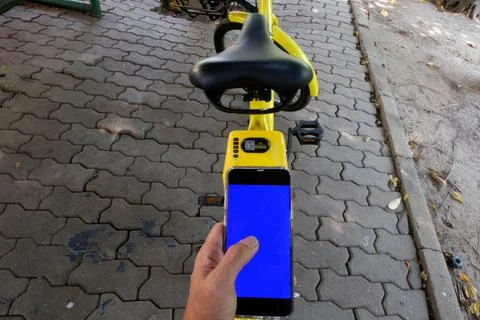 Man's hand scanning a QR code using smart phone to unlock bike,Modern smart p Stock Photos