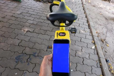 Man's hand scanning a QR code using smart phone to unlock bike,Modern smart p Stock Photos