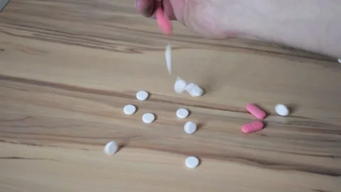 A man's hand scatters pills on the table Video stock 234341838