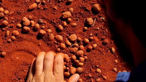 Man's Hand Scoops the Red Soil and Bauxite at the Bauxite Mine Stock Footage 100228768