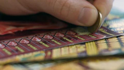 Man's Hand Scratching Lottery Tickets; Gambling Addiction Stock Footage