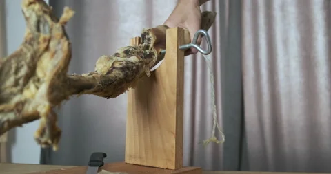 Man's hand, screwing an empty leg of jamon to the stand. Close-up. The concept Vídeo Stock 199587605