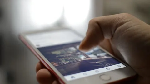 Man's hand scroll instagram social network on the iphone display screen. Stock Footage 238786798