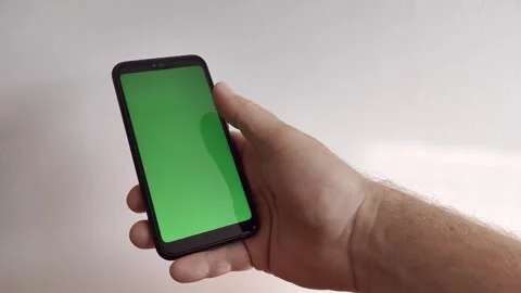 A man's hand scrolls through the tape on the phone from bottom to top. Green Video stock 259557317