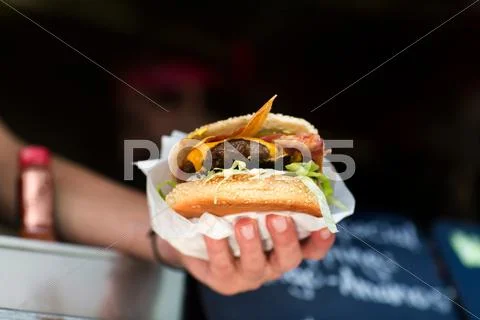 Man's Hand Serving Hamburger From Fast Food Van
