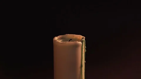 A man's hand sets fire to a candle on a black background with a match. Isolate Stock Footage 124860262